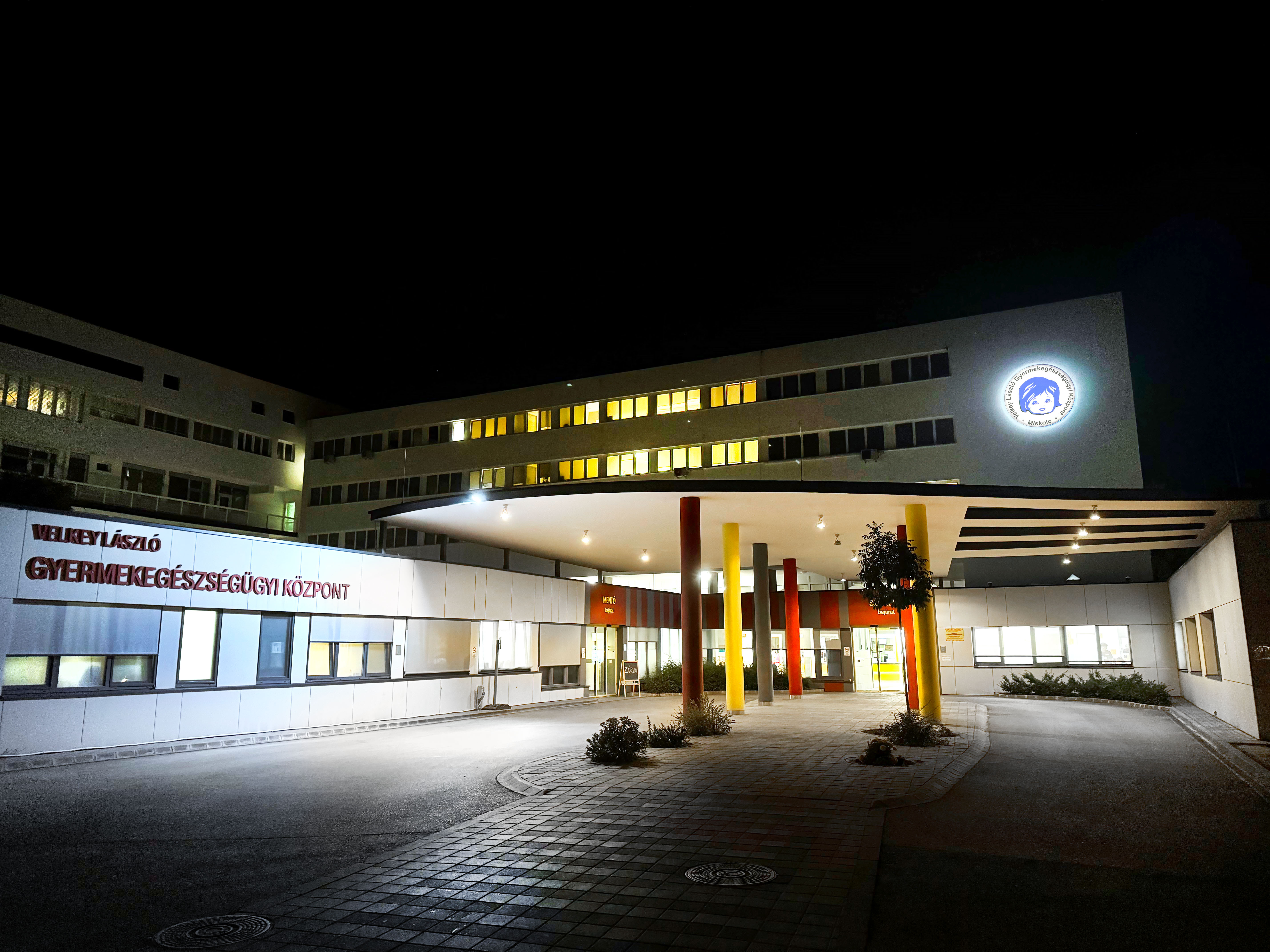 A GYEK kivilágított épülete a babafejes logóval