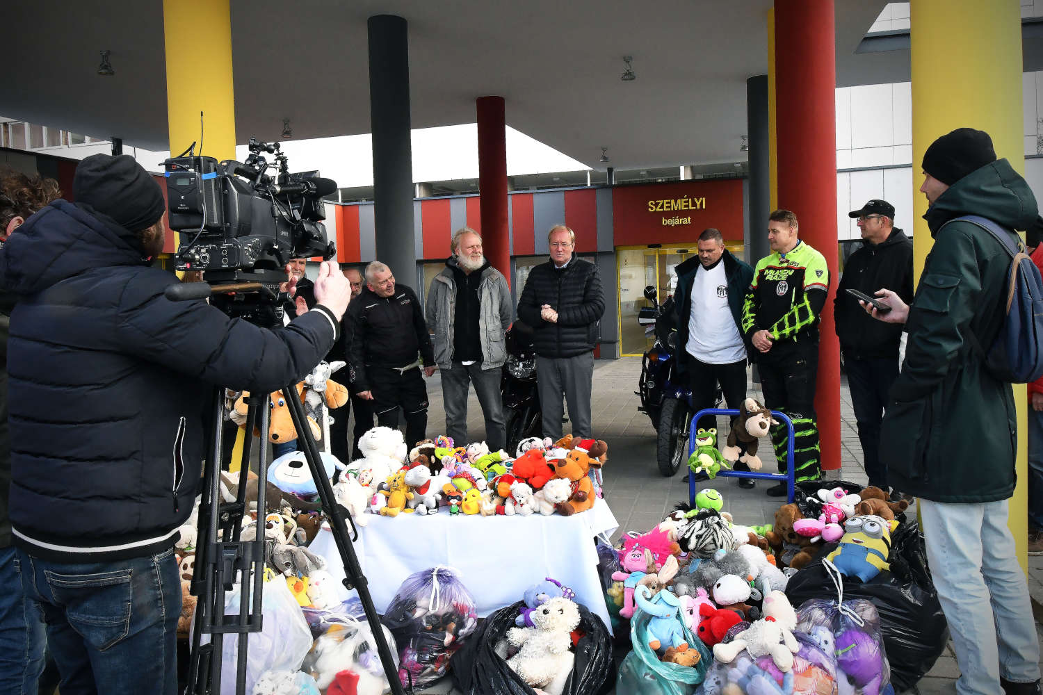 Emberek állnak az adományozott plüssjátékok körül