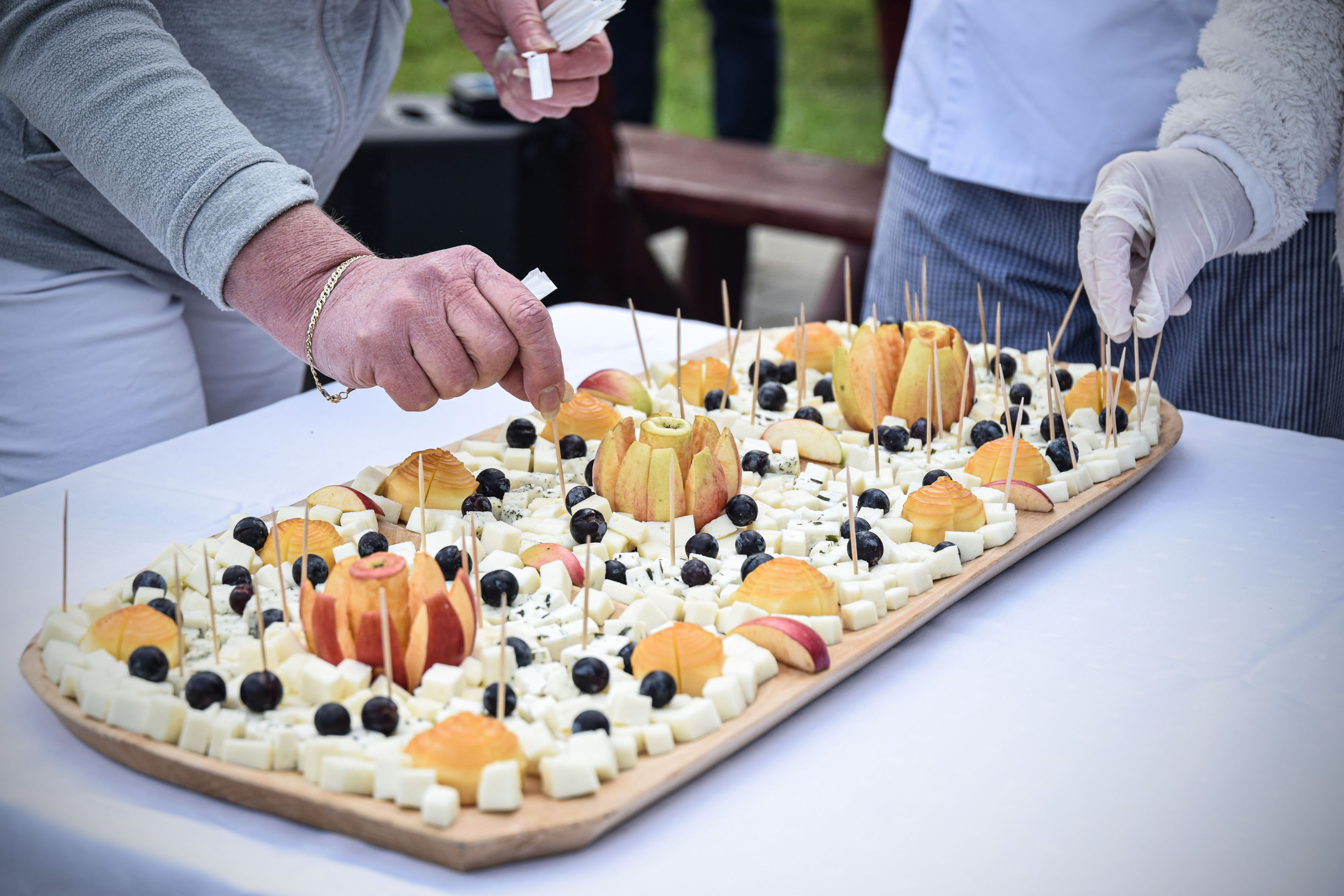 Egy kéz nyúl a sajt tálhoz