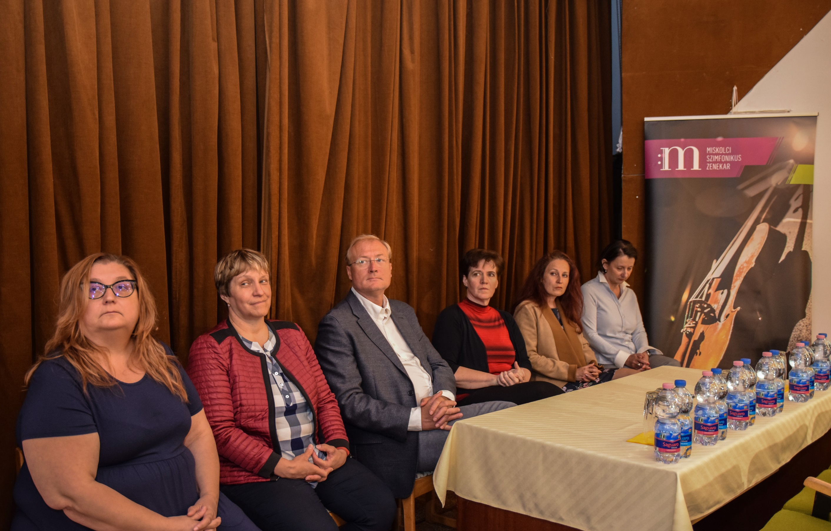 A sajtótájékoztató résztvevői ülnek egy asztalnál