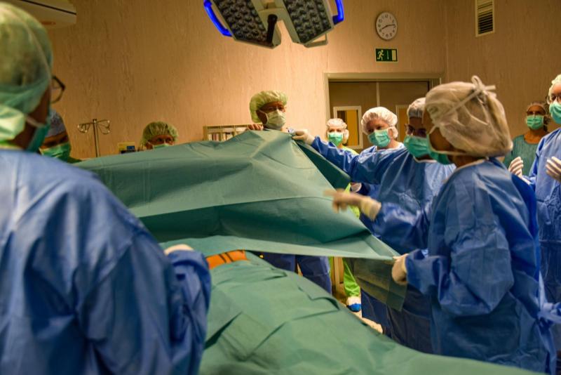Műtús ruhába öltözött látogatók a műtőben