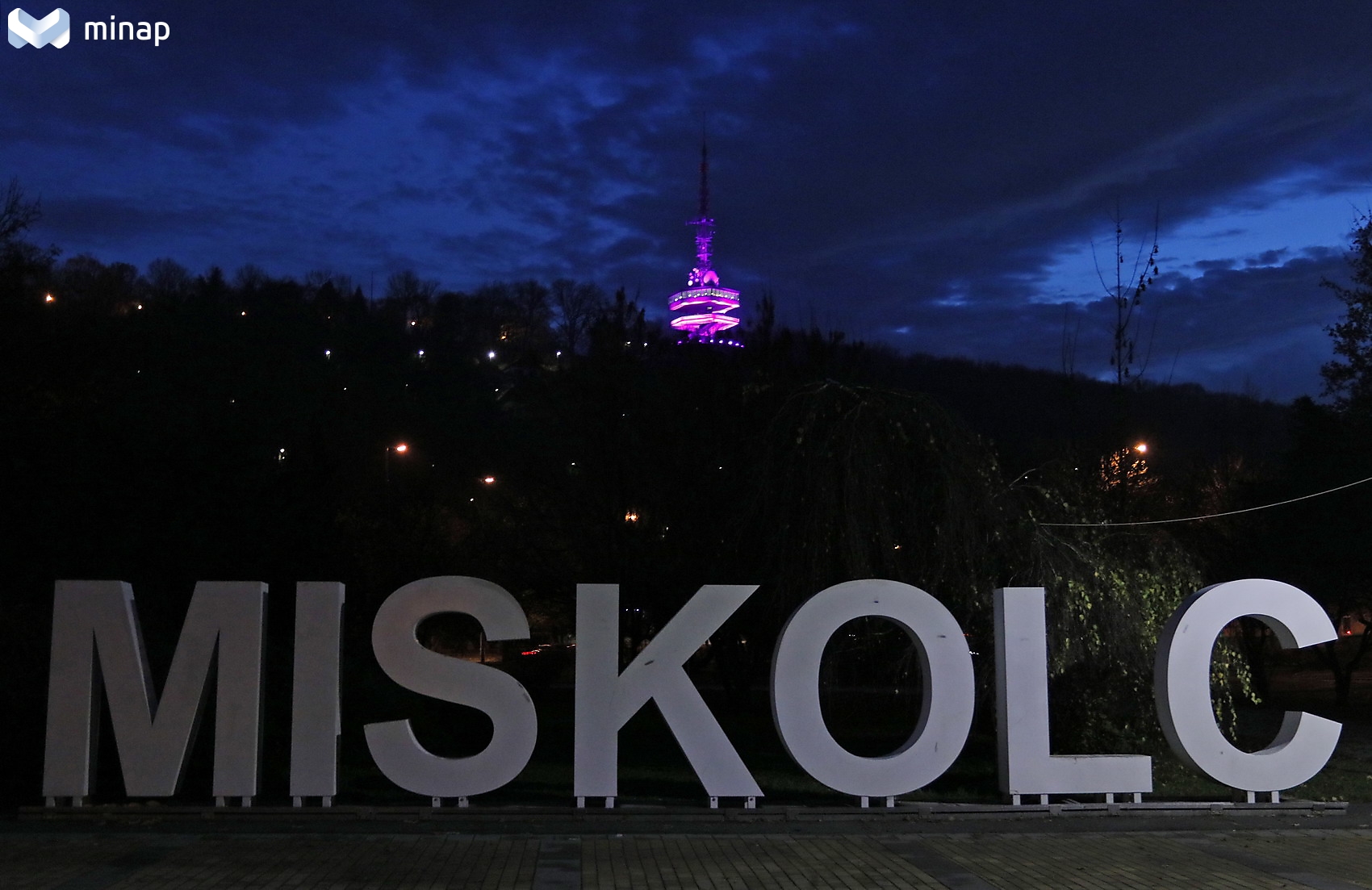 A Miskolc felirat mögött az Avasi kilátó lila színben megvilágítva