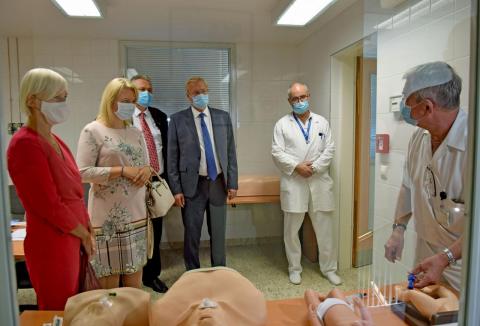 Orvosi maszkot viselő emberek állnak orvosi babák előtt